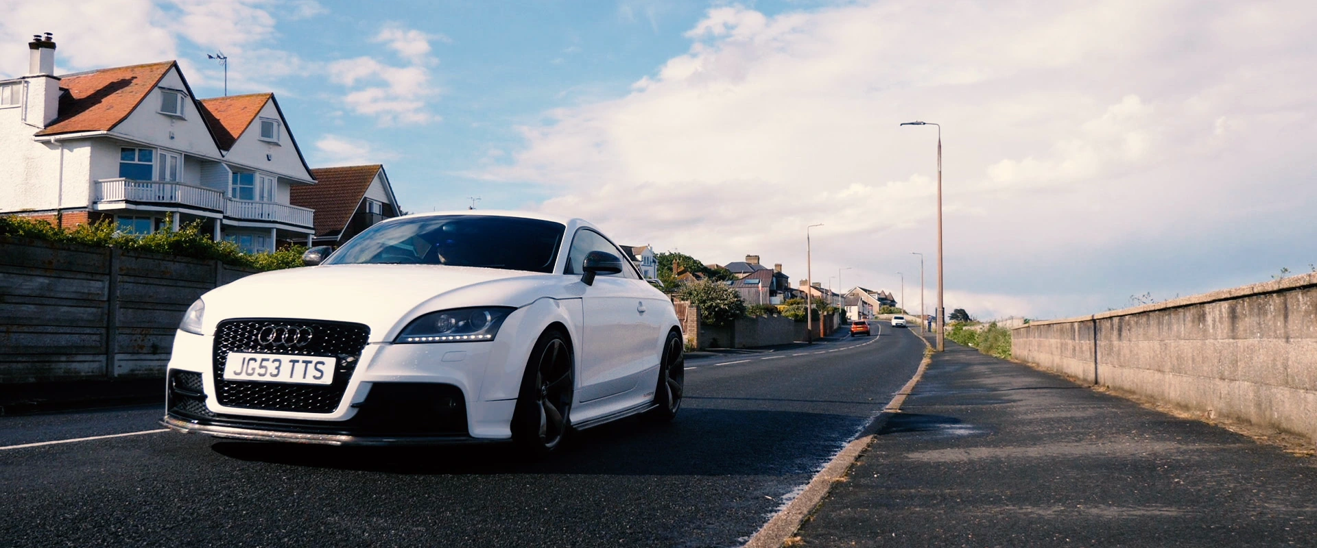 Front three-quarter view of a white Audi TT on a coastal road