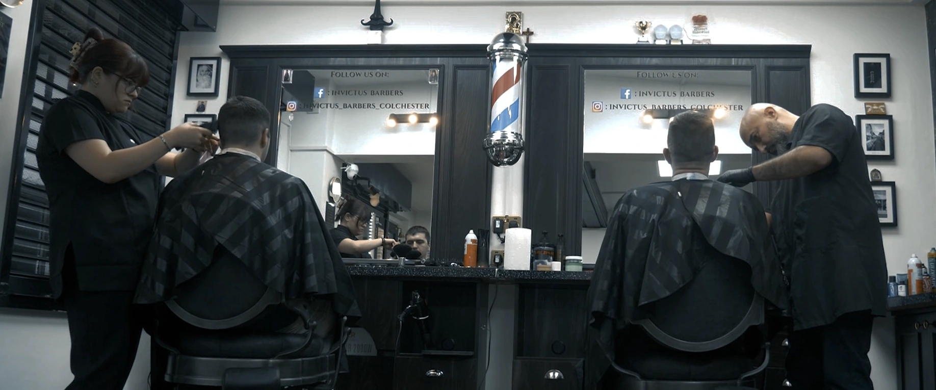 Inside Invictus Barbers, with barbers working at their chairs